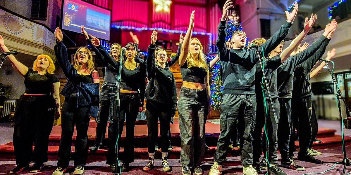 Performance Academy students singing at a college event